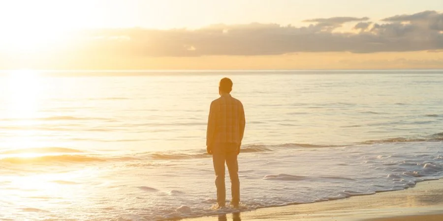 Person standing in peaceful sunrise representing finding worth in God and Christian identity, illustrating hope and bible verses about believing in yourself.