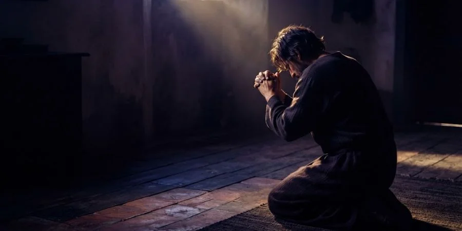 Figure kneeling in anguished prayer, capturing the raw honesty behind Bible verses about abandonment and feeling forsaken.
